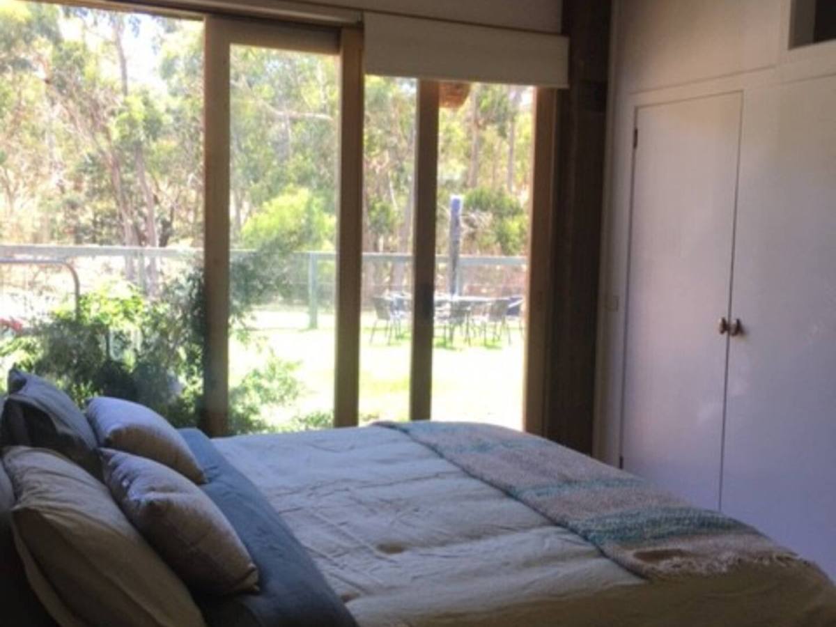 d897b208-9562-4c64-a366-660bda6ed4de a bedroom with a bed and a large window