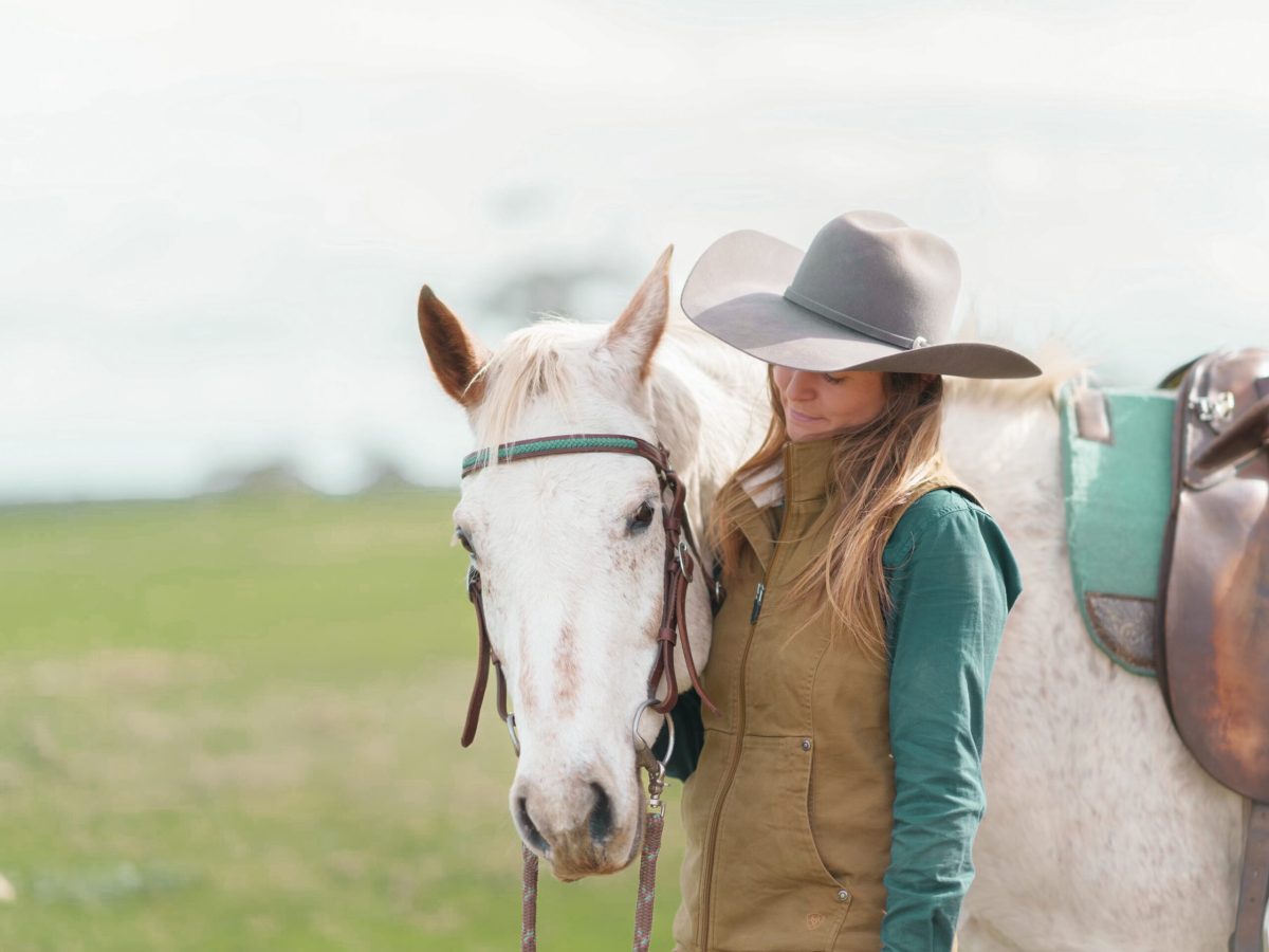 IMG_9746_jpg a person standing next to a horse