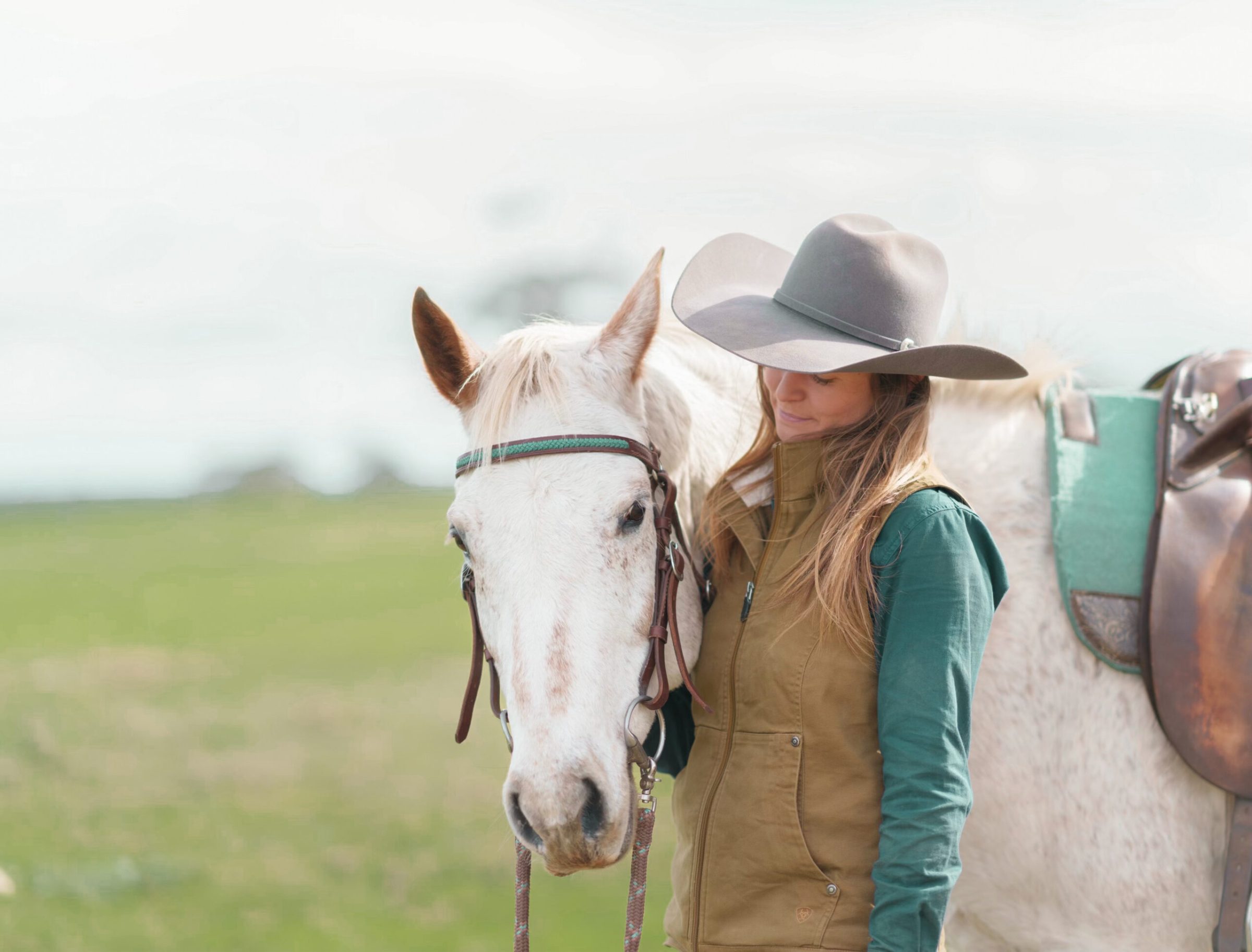 IMG_9746_jpg a person standing next to a horse