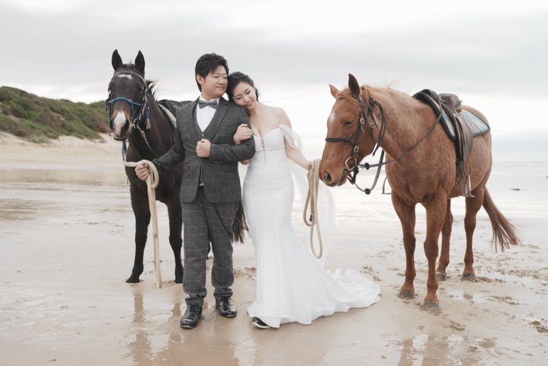 NEO07246 a couple of people that are sitting on a horse on a beach